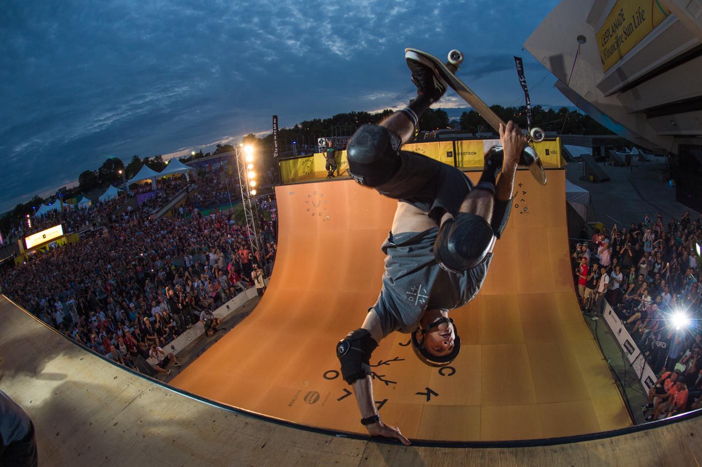 Tony Hawk inverted on the Jackalope vert ramp at Olympic Park, thousands watching at dusk