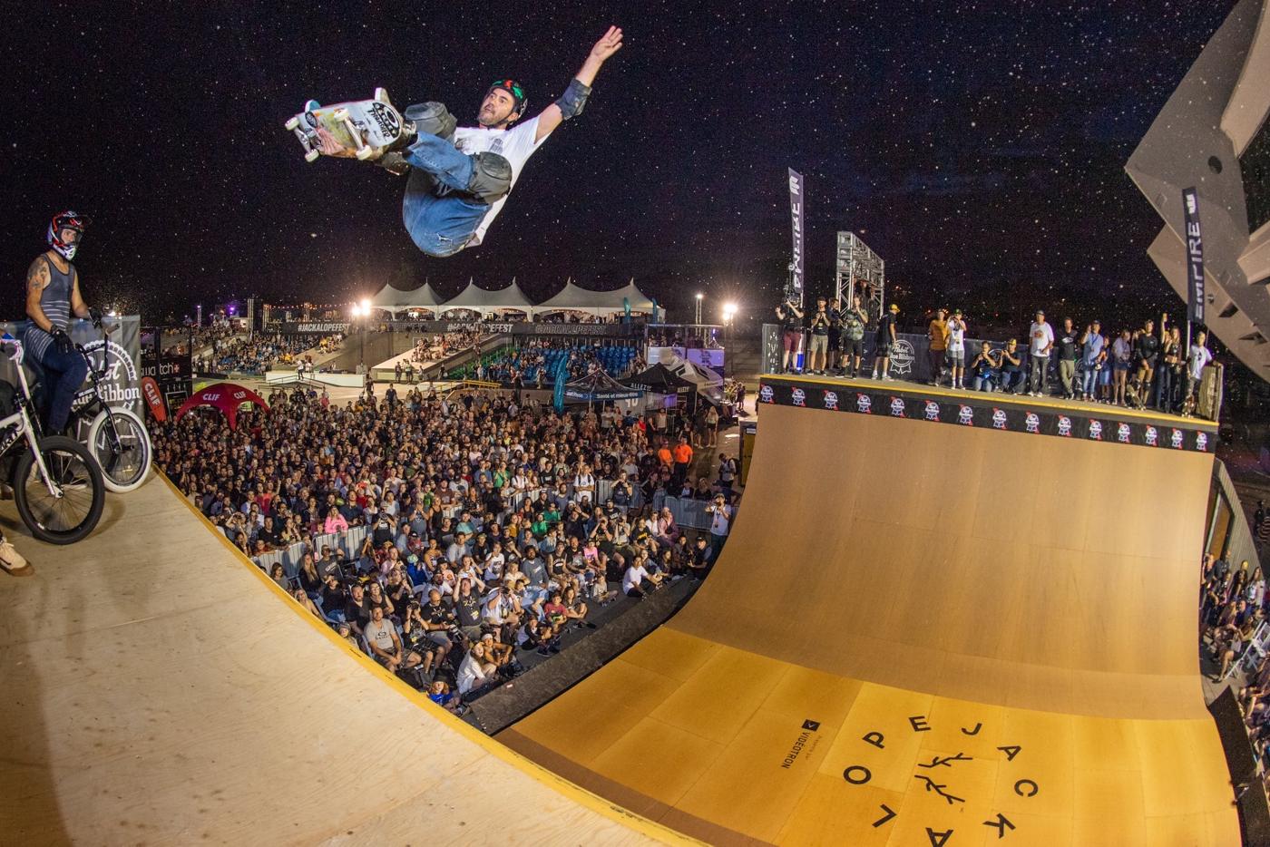 A vert skater under a starry sky above a packed crowd at Jackalope Montréal
